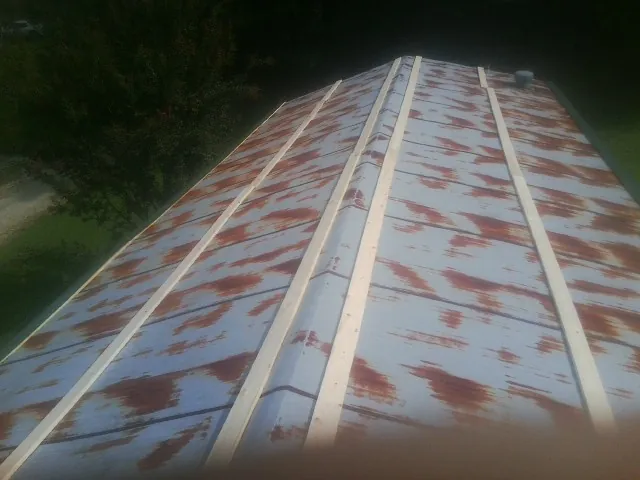 Rusted metal roof panels with new wood purlins before replacement — Storm Damage Roof Repair in Clarks Hill by Roofing Brothers