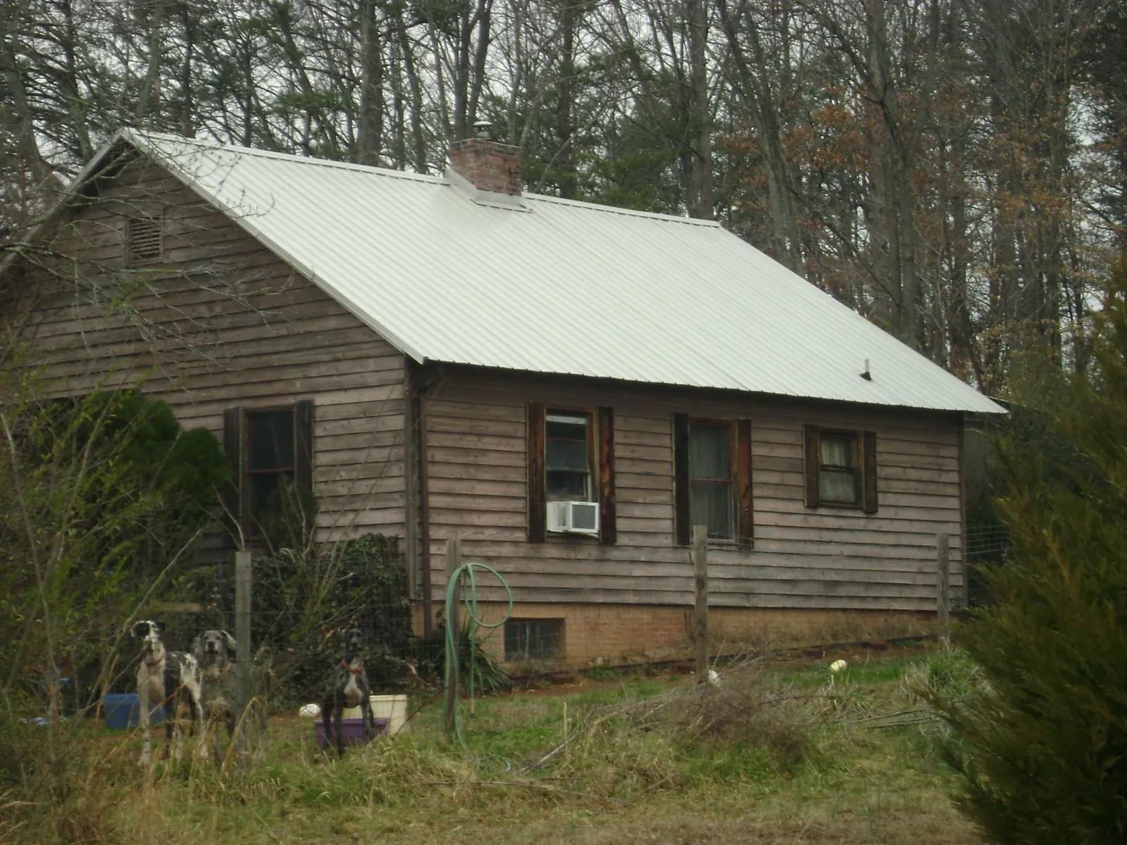 White metal roof on an old wood sided farmhouse, from a Asphalt Shingle Roof Repair job in Clarks Hill